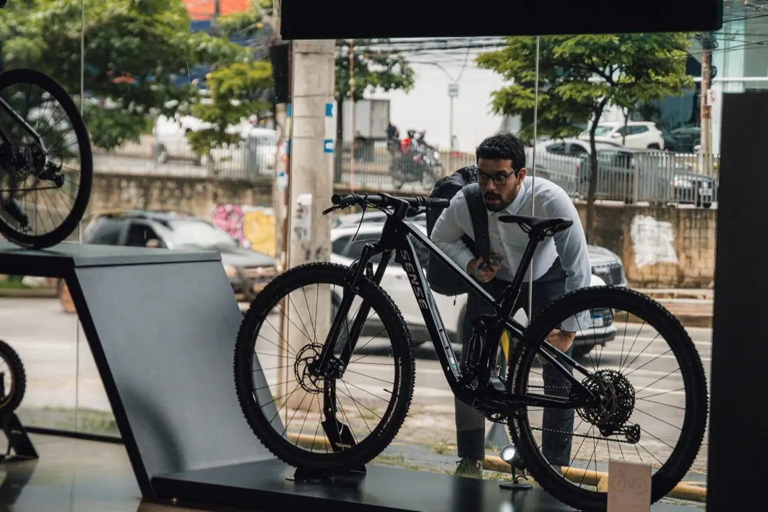 Cliente conhecendo uma bike Sense na vitrine da S2 Bike Shop Varginha